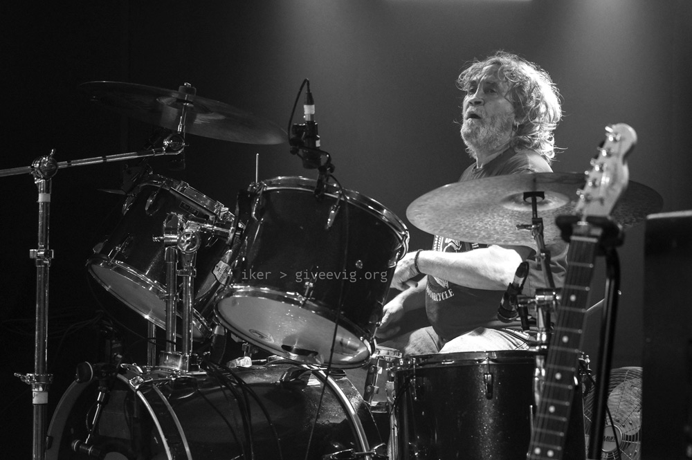 El baterista 'Koko' desde la parte derecha del escenario, mira atento a sus compañeros de escenario.