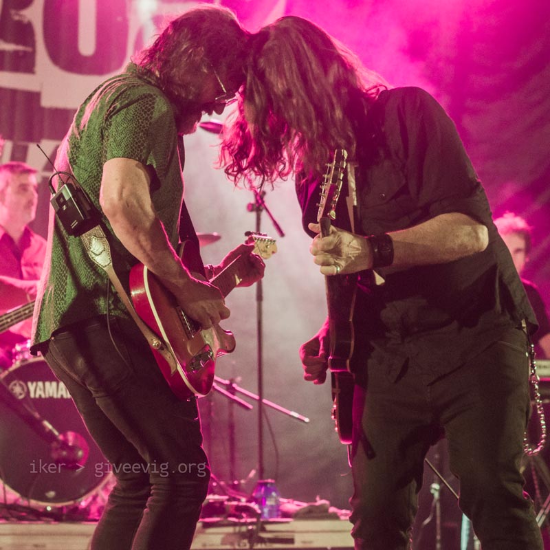 Gorka y Txus, uno frente al otro, mientras se apoyan mutuamente sus cabezas y tocan la guitarra.